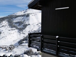 A mountain view with a wooden building and a ski slope.