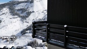 A mountain view with a wooden building and a ski slope.