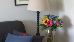 A room with a bed, a lamp, a vase with flowers, and two framed pictures on the wall. - Holiday home sleeps 6 central,  10 minute walk to golf course (Lahinch)