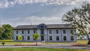 A large, historic stone building with a symmetrical facade, multiple windows, and a central entrance. - Hotel Palme Dalyan (Ortaca)