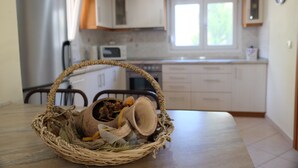 A kitchen with white cabinets, a microwave, and a window. - BILLIAS HOUSE VOURVOUROU 4-room house, 8 people with great views of the sea (vourvourou)