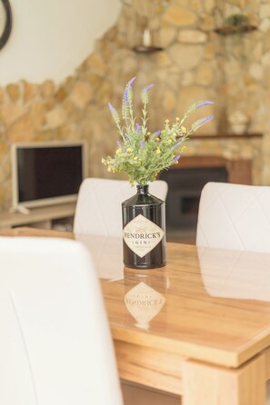 Un tavolo con un vaso di fiori e una bottiglia con l'etichetta "Hendricks".