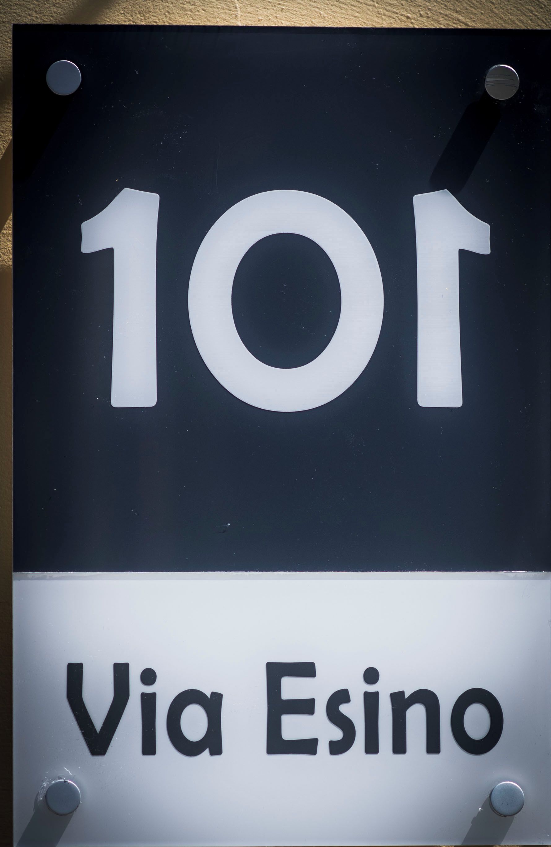 A sign with the number 101 and the text "Via Esino".