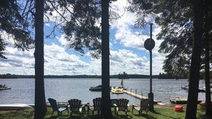 A lakeside view with chairs and a dock. - Sandy Beach Cottage on Chandos Lake (Apsley)