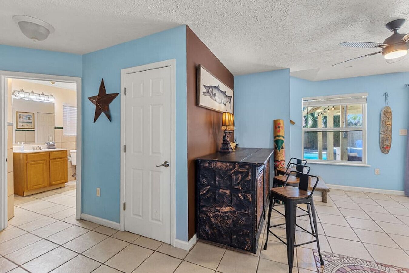 A kitchen with a dark marble island, a star decoration on the wall, and a window with a view of the outdoors.