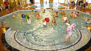 Une grande piscine intérieure dotée de plusieurs couloirs et d’un espace central dédié aux activités aquatiques.
