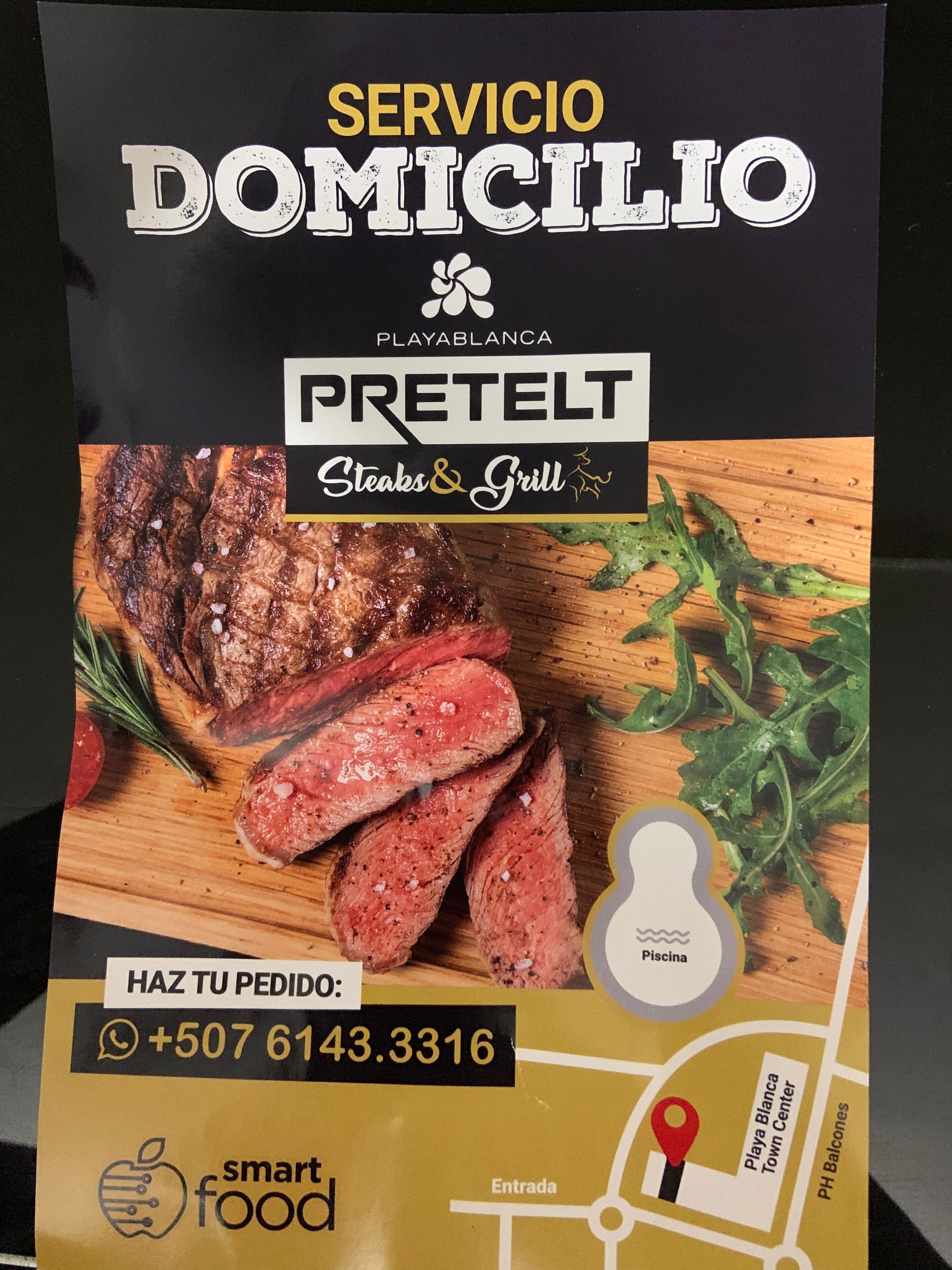 Borsa per la consegna di cibo con menu che mostra una bistecca e una griglia, numero di contatto e mappa che indica la posizione.