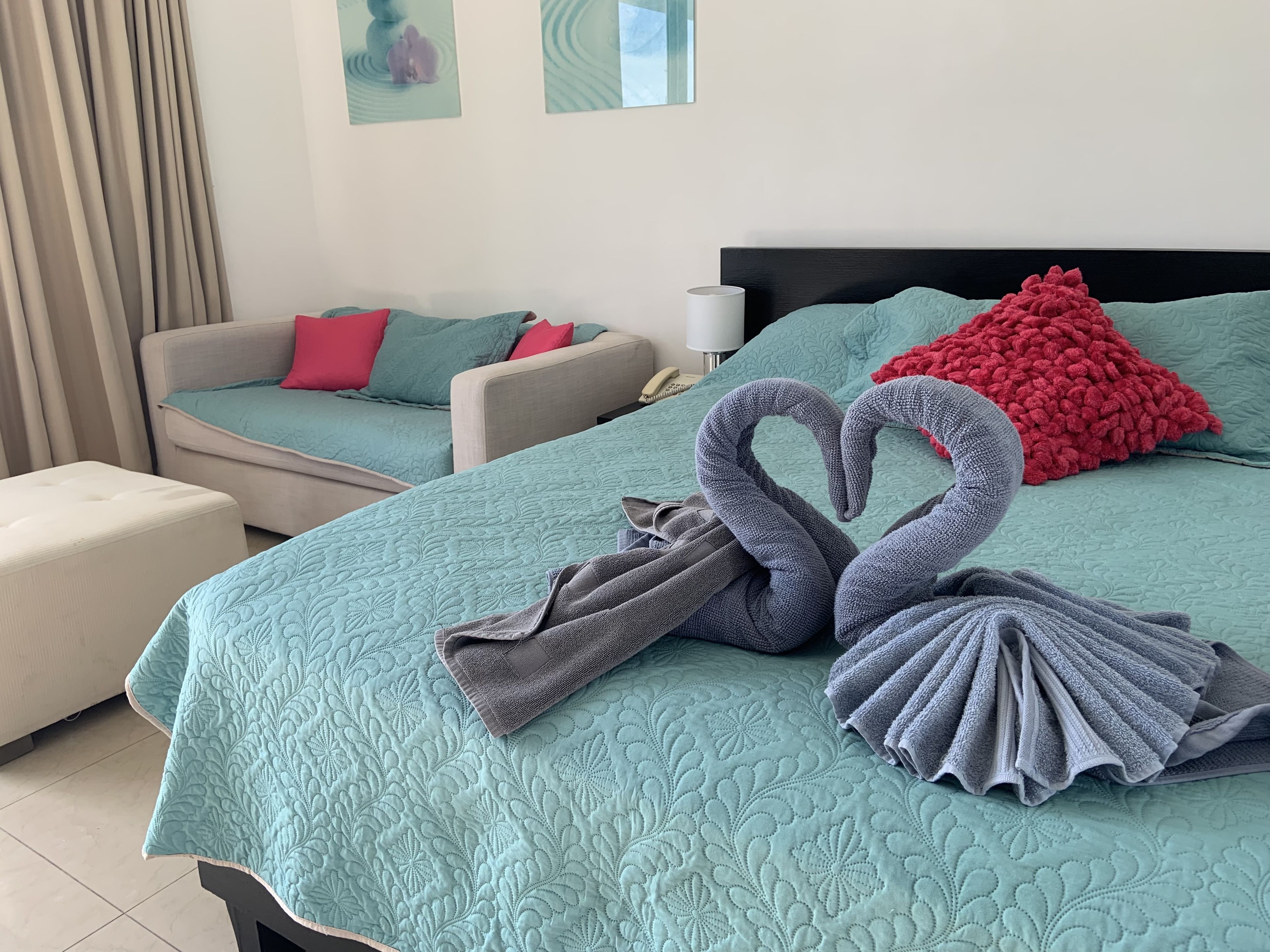 Una habitación de hotel con una cama, dos sofás y una mesita de noche.