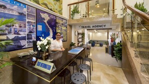 Una recepción con un cartel que dice 'Tour Information', un cartel que dice 'Travel Agency' y un mapa de Vietnam.