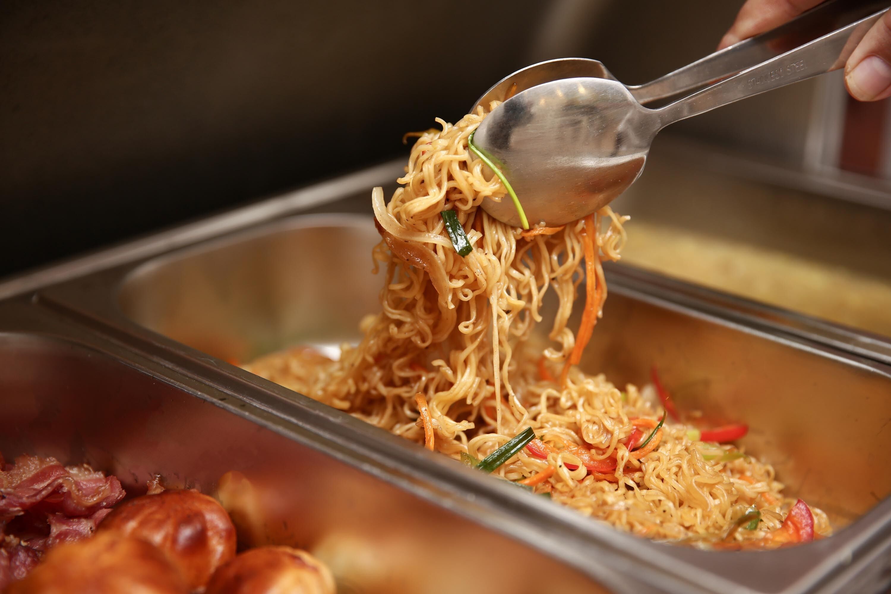 Un tenedor levantando fideos de un recipiente.