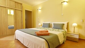 Een slaapkamer met een bed, nachtkastjes, een garderobe en wandlampen.