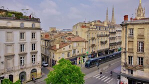 A cityscape with historic buildings, a tram, and a church spire. - La Suite - Studio Apartment, Sleeps 2 (Bordeaux)