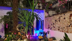 A courtyard with potted plants, flowers, and a stone wall. - La casa di Daniele (Brescia)