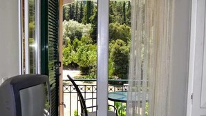 Un balcón con vista a un jardín y árboles.