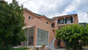 Una casa de dos pisos con un porche cubierto, una escalera y un garaje.