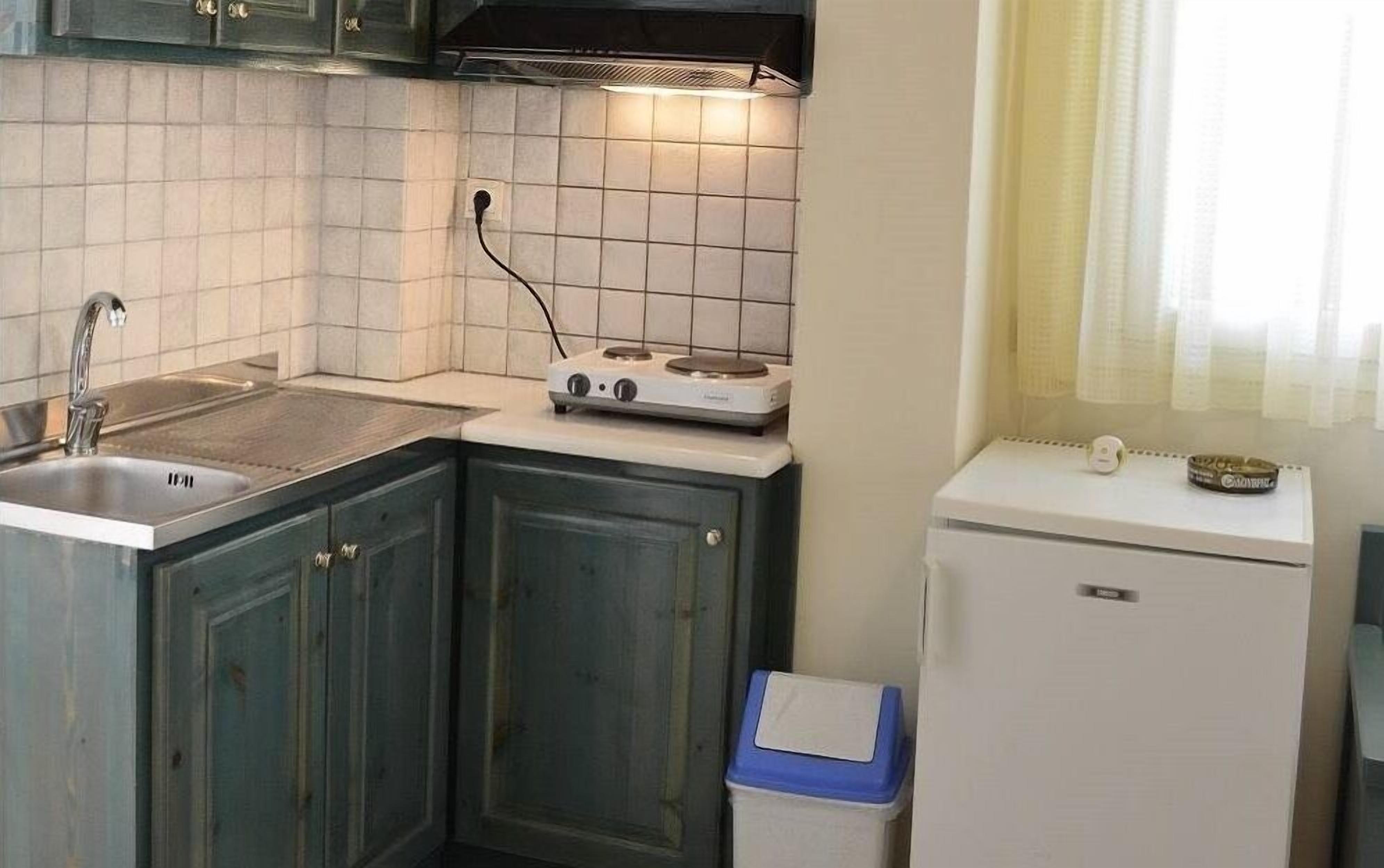 A compact kitchen with a sink, stove, and refrigerator.