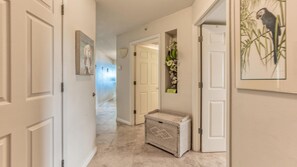 Stylish hallway with a wicker basket and framed artwork, leading to an entrance.