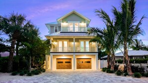 A two-story house with a balcony, two garages, and a paved driveway. - Beach Views - Family-Friendly, Steps to Lido Beach! (Lido Key)
