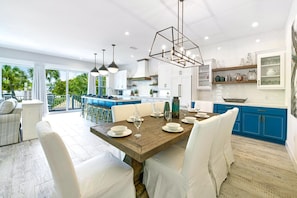 A modern kitchen with a central island, white and blue cabinetry, and pendant lighting. - Beach Views - Family-Friendly, Steps to Lido Beach! (Lido Key)