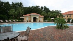 A swimming pool with lounge chairs and a small building in the background. - Your Orlando theme park and shopping paradise!       Long term renters welcome (Kissimmee)
