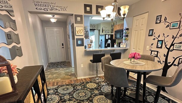 A modern kitchen with a central island, a dining area with a round table and chairs, and a patterned rug. - Your Orlando theme park and shopping paradise!       Long term renters welcome (Kissimmee)