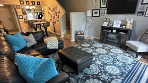 A modern living room with a black leather sofa, a patterned rug, and a ceiling fan. - Your Orlando theme park and shopping paradise!       Long term renters welcome (Kissimmee)