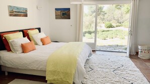 Une chambre à coucher avec un lit, des oreillers, un tapis et un tableau au mur.