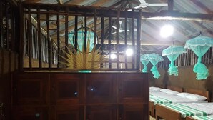 Una habitación con muebles de madera, incluyendo una cama con ropa de cama verde y blanca, un armario de madera y un ventilador de techo.