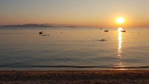A calm sea at sunset with boats and a clear sky. - Zmas Studios (South Pelion)