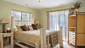 A rustic wooden bed with a headboard, bedside lamps, and a bedside table with a lamp and a box. - Grand Canyon Loft/Suite at Historic Wrigley Ranch-Horseback Ride-Target Shoot! (Parks)