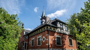 A historic building with a prominent tower, large windows, and a symmetrical facade. - Apartment in historical building - old school (Spittelstein)