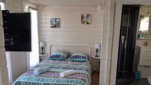 Un lit avec une couvre-lit à rayures, deux lampes de chevet et une petite table de chevet avec une lampe.