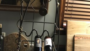 A wine rack holding two bottles, a corkscrew, and a wooden box labeled "IN ARKANSAS" on a kitchen counter. - Cabin in the woods between Mt. Nebo and Mt. Magazine (Dardanelle)