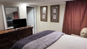 A bedroom with a bed, a dresser, a television on the dresser, and framed pictures on the wall. - Professional, Travelers Haven , 1 bdrm, living room, private shower free parking (Martinez)