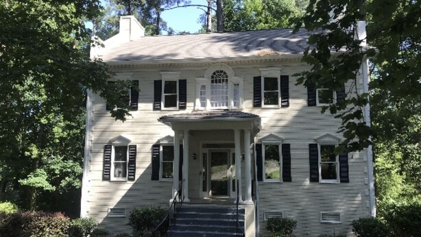A two-story house with a central entrance, a porch with columns, and a staircase leading to the front door. - Professional, Travelers Haven , 1 bdrm, living room, private shower free parking (Martinez)