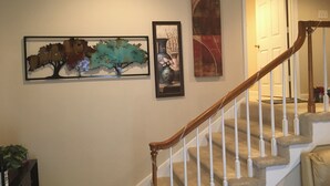 A staircase with a wooden handrail and white balusters, leading to a door. - Professional, Travelers Haven , 1 bdrm, living room, private shower free parking (Martinez)