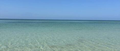 Ranta lähistöllä, aurinkotuoleja, rantapyyhkeitä