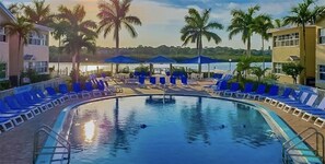 Relax by the pool surrounded by lush palm trees and comfortable lounge chairs.