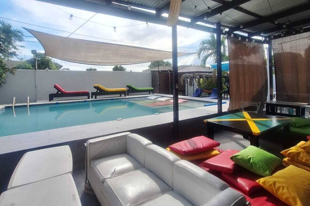 An outdoor pool area with lounge chairs and a covered seating area.