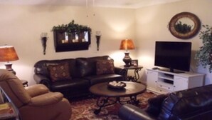 Un soggiorno con un divano, un tavolino, una TV e applique decorative.