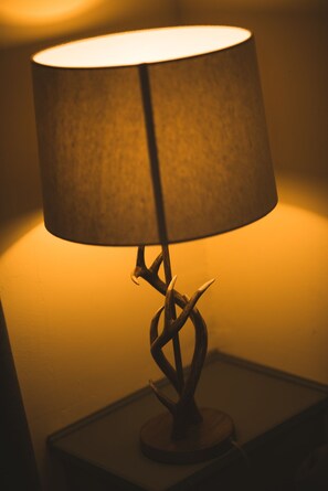 A table lamp with a cylindrical shade and a twisted metal base. - STAG city centre studio apartment (Inverness)