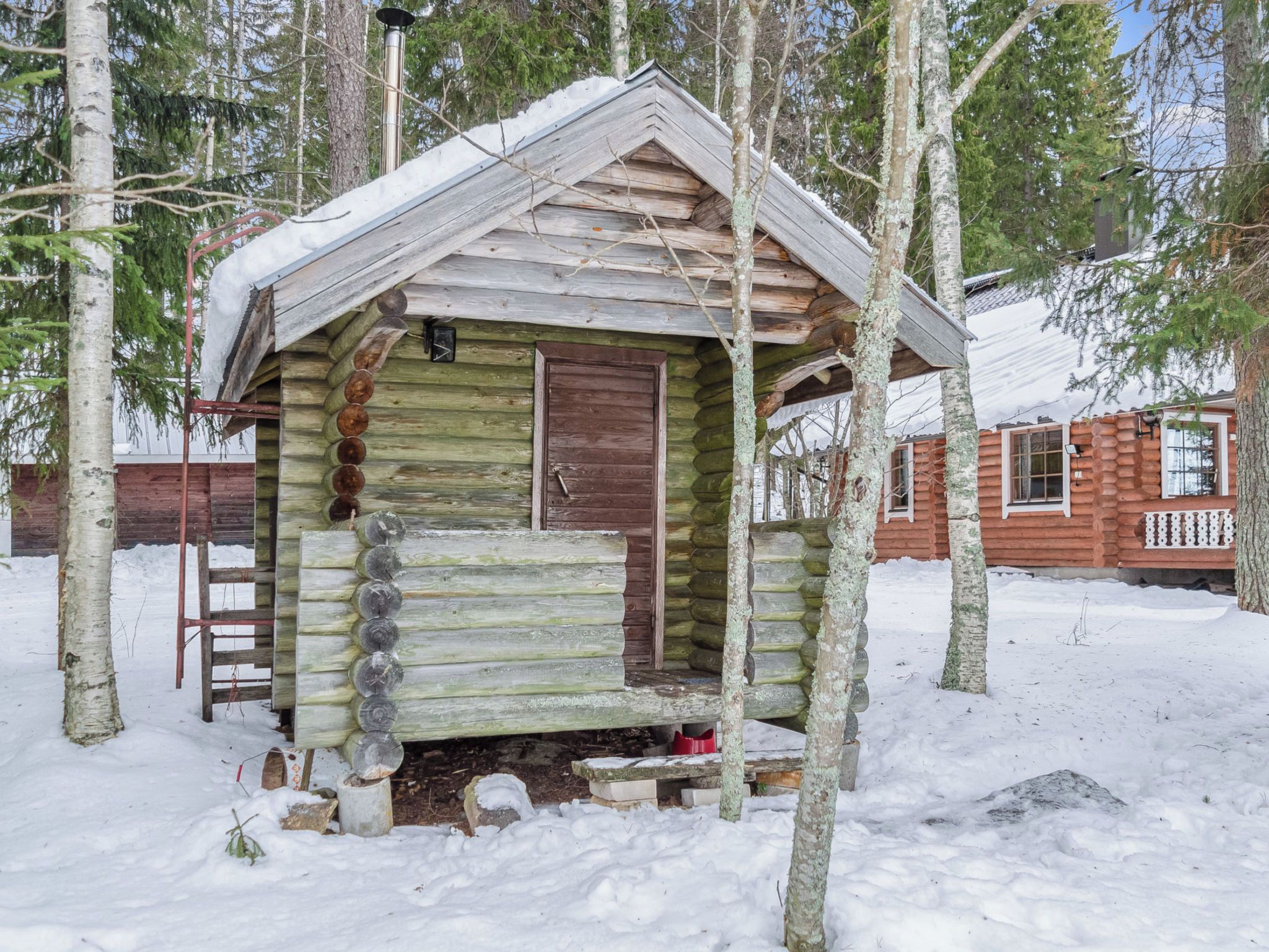 Eine Blockhütte mit Holztür und einer kleinen Veranda.