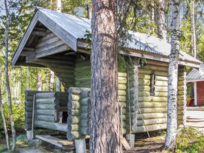A rustic log cabin with a sloped roof, a chimney, and a small porch area. - Lohi, lie14 by Interhome (Lieksa)
