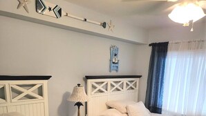 A hotel room with two beds, a nightstand with a lamp, and decorative wall art. - Beach Block Wildwood Crest Condo (Wildwood Crest)