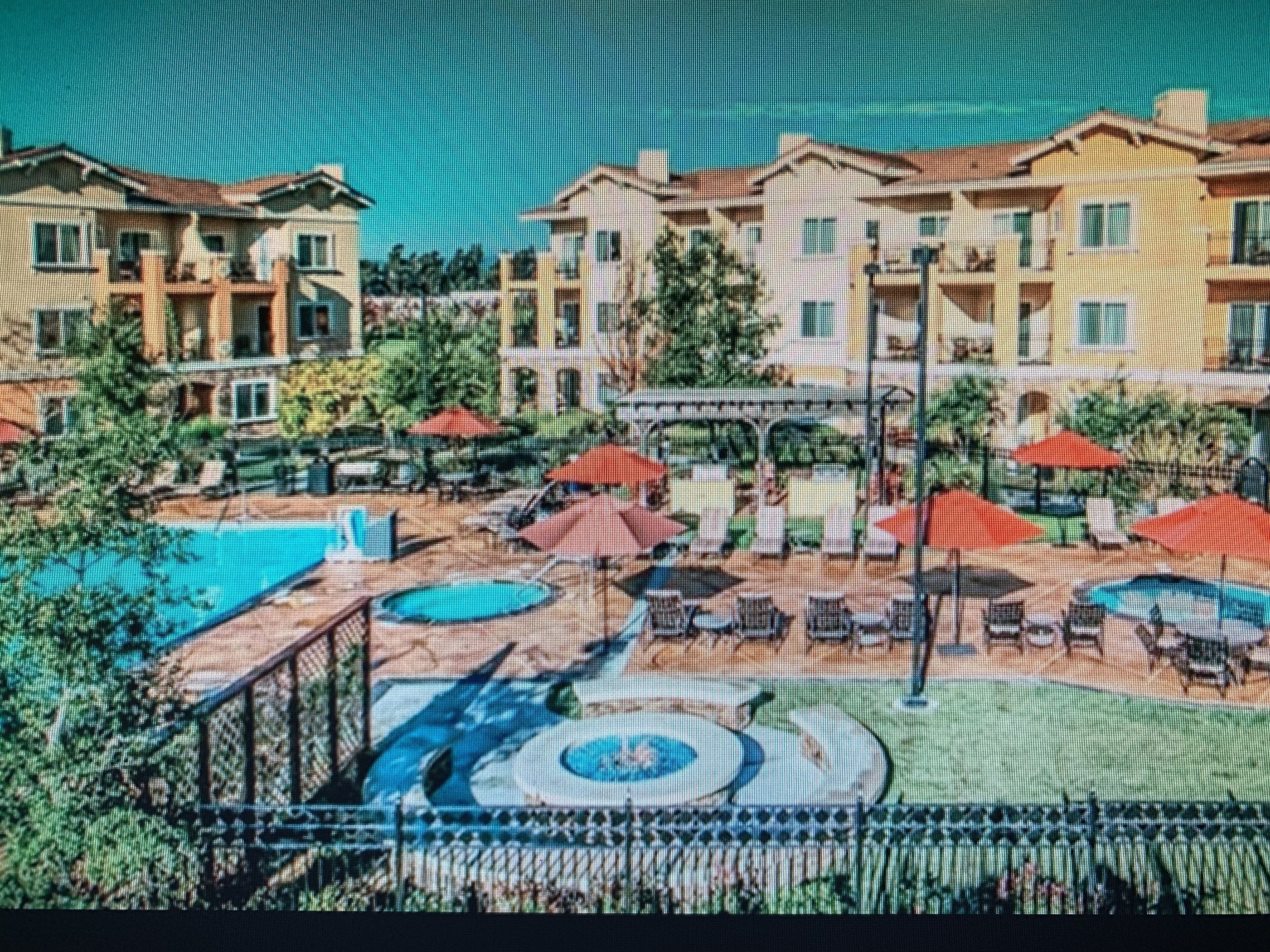Um hotel com área de piscina, mobiliário de exterior e jardim.