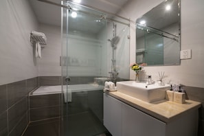 Habitación Deluxe (Grand) | Baño | Tina y regadera independientes, secadora de cabello, pantuflas, toallas 