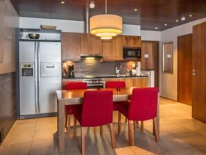 Enjoy meals at the central island or dining table, equipped with a stove, microwave, and refrigerator.