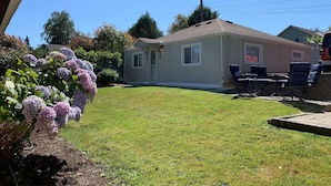 A single-story house with a front yard, a patio with outdoor furniture, and a garage.