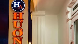 A hotel sign with illuminated letters spelling "HUONG ANH" and a circular logo above it. - Huong Anh Luxury Hotel Dalat (Lang Biang - Da Lat)