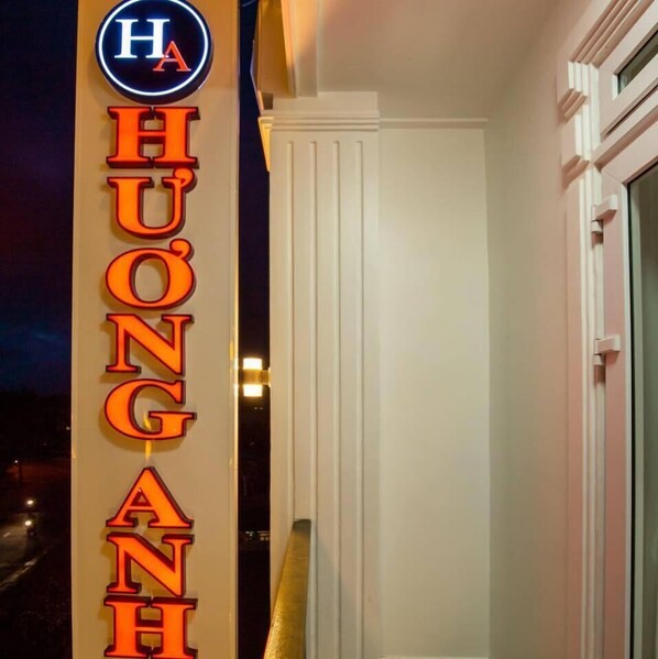 A hotel sign with illuminated letters spelling "HUONG ANH" and a circular logo above it. - Huong Anh Luxury Hotel Dalat (Lang Biang - Da Lat)